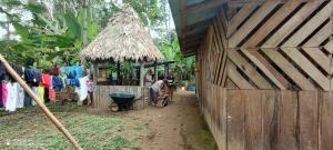 a person sitting in a chair outside of a shack at Lodging and Adventure in Soposo