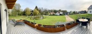 een terras met een tafel en stoelen en een tuin bij Chalet am Mollcesine in  Oderwitz
