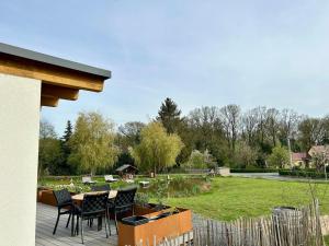 um pátio com cadeiras, uma mesa e um jardim em Chalet am Mollcesine em  Oderwitz
