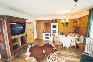 Stodingerhuette في Koppl: غرفة طعام مع طاولة وتلفزيون