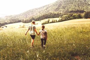 two women walking through a field of tall grass at Stodingerhuette in Koppl