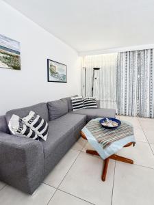 a living room with a gray couch and a table at Reihenendhaus Marina Sol in Dahme