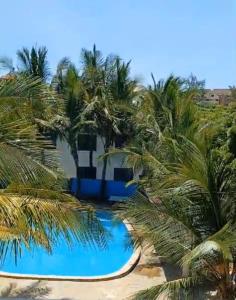 Blick auf ein Resort mit Palmen in der Unterkunft Bedroom Diani Beach in Diani Beach