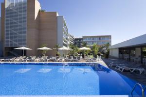 uma grande piscina com cadeiras e guarda-sóis em Altafulla Mar Hotel em Altafulla