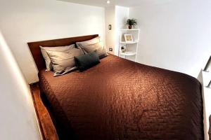 een slaapkamer met een groot bruin bed met 2 kussens bij Urban Shelter, El Dorm. 413 in Guatemala