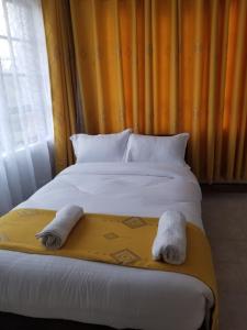 a bedroom with a bed with two towels on it at 7 Days Holiday Inn in Nairobi
