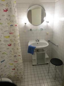a bathroom with a sink and a shower curtain with fish on it at Rosa Canina, W3 in Kellenhusen
