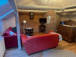 ein Wohnzimmer mit zwei roten Sofas und einem TV in der Unterkunft Landhaus up Diek in Wittmund