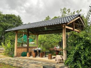 a wooden gazebo with a picnic table and a table at Dìn Homestay Nặm Đăm in Ha Giang