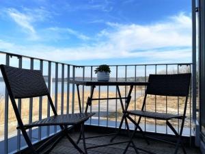 a balcony with two chairs and a table with a plant at Appartment Seeblick 4 1OG Grundbelegung 4 Pers in Elsterheide