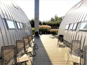 a row of chairs sitting on a wooden deck at Appartment Seeblick 4 1OG Grundbelegung 4 Pers in Elsterheide +14 photos