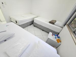 um quarto com duas camas e uma janela em Quarto Privativo em Condominio no Rio de Janeiro