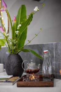 een houten tafel met een vaas en een glazen container bij CloverHome in Dong Hoi