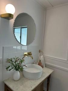 y baño con lavabo blanco y espejo. en Clementine Cottage en Crows Nest