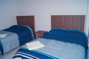 1 Schlafzimmer mit 2 Betten mit blauer und weißer Bettwäsche in der Unterkunft Centro Expositor, Feria de Puebla, Estadios, Acuario #1 in Puebla