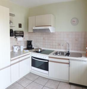 a white kitchen with a sink and a stove at Ferienhof Manowski Nr1 in Hinrichsdorf
