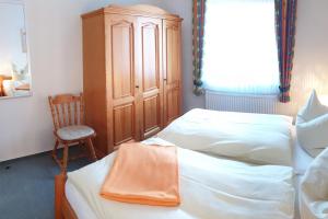 um quarto com 2 camas e um armário de madeira em Ferienhof Manowski Nr1 em Hinrichsdorf