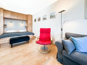 a bedroom with a bed and a red chair at FeWo Ferienglück Berolina 131 in Dahme