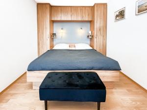 a bedroom with a large bed with a black ottoman at FeWo Ferienglück Berolina 131 in Dahme