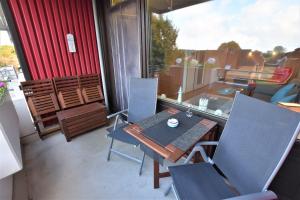 a patio with a table and chairs on a balcony at FeWo Ferienglück Berolina 131 in Dahme +13 photos