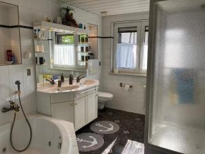 een badkamer met een bad, een wastafel en een toilet bij Ferienwohnung Blessbergblick in Eisfeld