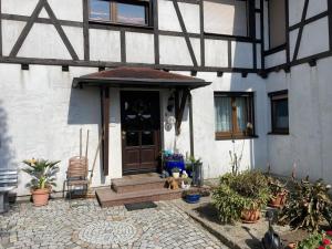 une porte d'entrée d'une maison avec des plantes en pot dans l'établissement Ferienwohnung Blessbergblick, à Eisfeld