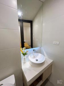 Baño blanco con lavabo y espejo en Tglobal Apartment 204 Trần Duy Hưng en Hanói