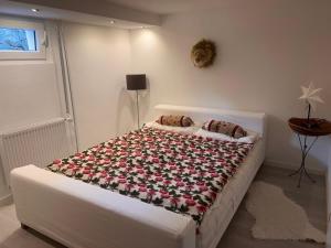 Un dormitorio con una cama con una manta de flores. en Charmante Einliegerwohnung, 3 Zimmer in ruhiger Wohnlage, 60qm, mit gemütlicher Südterrasse en Marburg an der Lahn