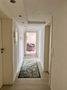 um corredor vazio com um tapete no chão em Charmante Einliegerwohnung, 3 Zimmer in ruhiger Wohnlage, 60qm, mit gemütlicher Südterrasse em Marburgo