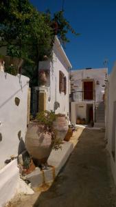 a white building with plants in pots next to a street at Ferienhaus in Pefki mit Terrasse und Grill in Pévkoi