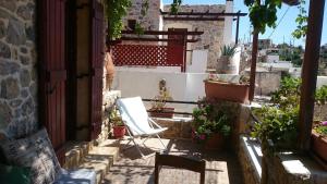 a patio with a chair and some potted plants at Ferienhaus in Pefki mit Terrasse und Grill in Pévkoi
