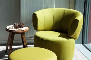 a green chair with a plate of food on a table at Ostsee - Reetdachhaus Nr 14 "DasRoteHaus" im Strand Resort in Heiligenhafen