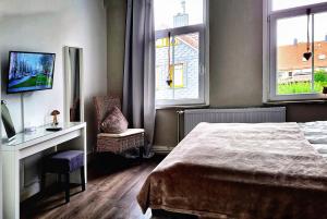 1 Schlafzimmer mit einem Bett, einem Schreibtisch und 2 Fenstern in der Unterkunft Casa Diaz in Bad Harzburg