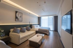 una camera d'albergo con divano e letto di Shanming Boutique Homestay a Fenghuang