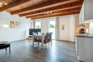 a kitchen and dining room with a table and chairs at Nr 1 Meerhusen - Barrierefrei in Aurich