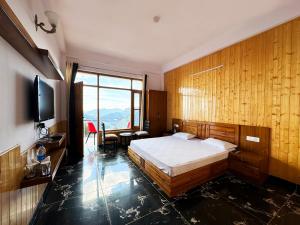 1 dormitorio con cama y ventana grande en Hawk Eye Resort, en Shimla