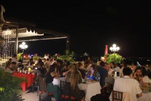 巴色的住宿－Pakse hotel & Restaurant，一群人晚上坐在餐馆的桌子上