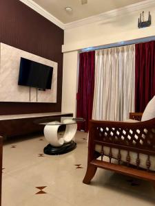 a living room with a tv and a couch and a chair at Coast & Comfort Stays - 2 BHK home in Panjim in Panaji