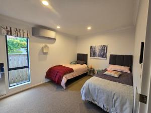 1 Schlafzimmer mit 2 Betten und einem Fenster in der Unterkunft Modern family oasis in Clive in Clive