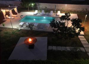 una vista aérea de una piscina por la noche en B&B Casa Karina Pool&Rooms, en Specchia