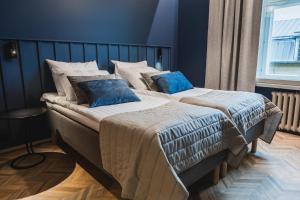 a bedroom with two beds with blue pillows at Ineon Hotel in Turku