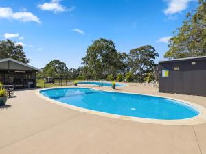 a swimming pool at a park with trees in the background at Valla Beach Holiday Park in Valla Beach