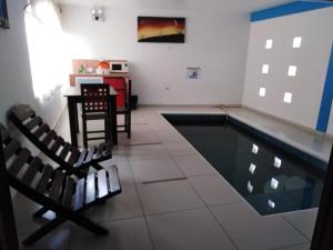 einen Pool mit 2 Stühlen und einem Tisch in der Unterkunft Apartamentos Mar y sol in Chachalacas