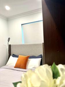 - une chambre avec un lit et un oreiller orange dans l'établissement Private 1 Bed Accom with Bathroom in a 3 Bed Apartment - Melb CBD, Regency Towers - Free Parking, WiFi and Pool, à Melbourne