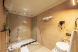 uma casa de banho com um chuveiro, um WC e um lavatório. em Ra Vista em kolkata