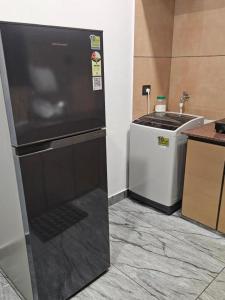 a refrigerator in a kitchen next to a sink at MATHER RAJAGIRI FURNISHED APARTMENTS in Alwaye