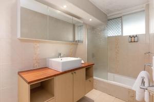 a bathroom with a white sink and a shower at Hi Ho Beach Apartments on Broadbeach in Gold Coast
