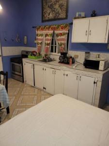 a kitchen with white cabinets and a blue wall at Country Style living in Albion
