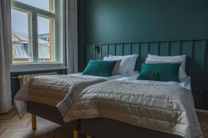 1 dormitorio con 2 camas y almohadas verdes en Ineon Hotel, en Turku