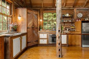 a large kitchen with wooden walls and wooden floors at Restdown Kangaroo Valley in Barrengarry